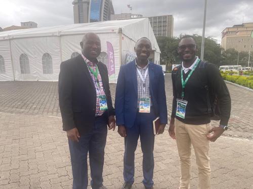Photo of iSDA's Director of Operations, Bruce Kisitu, at the AFSH Summit 2024 with IAPRI researchers Stephen Kabwe and Brian Mulenga.